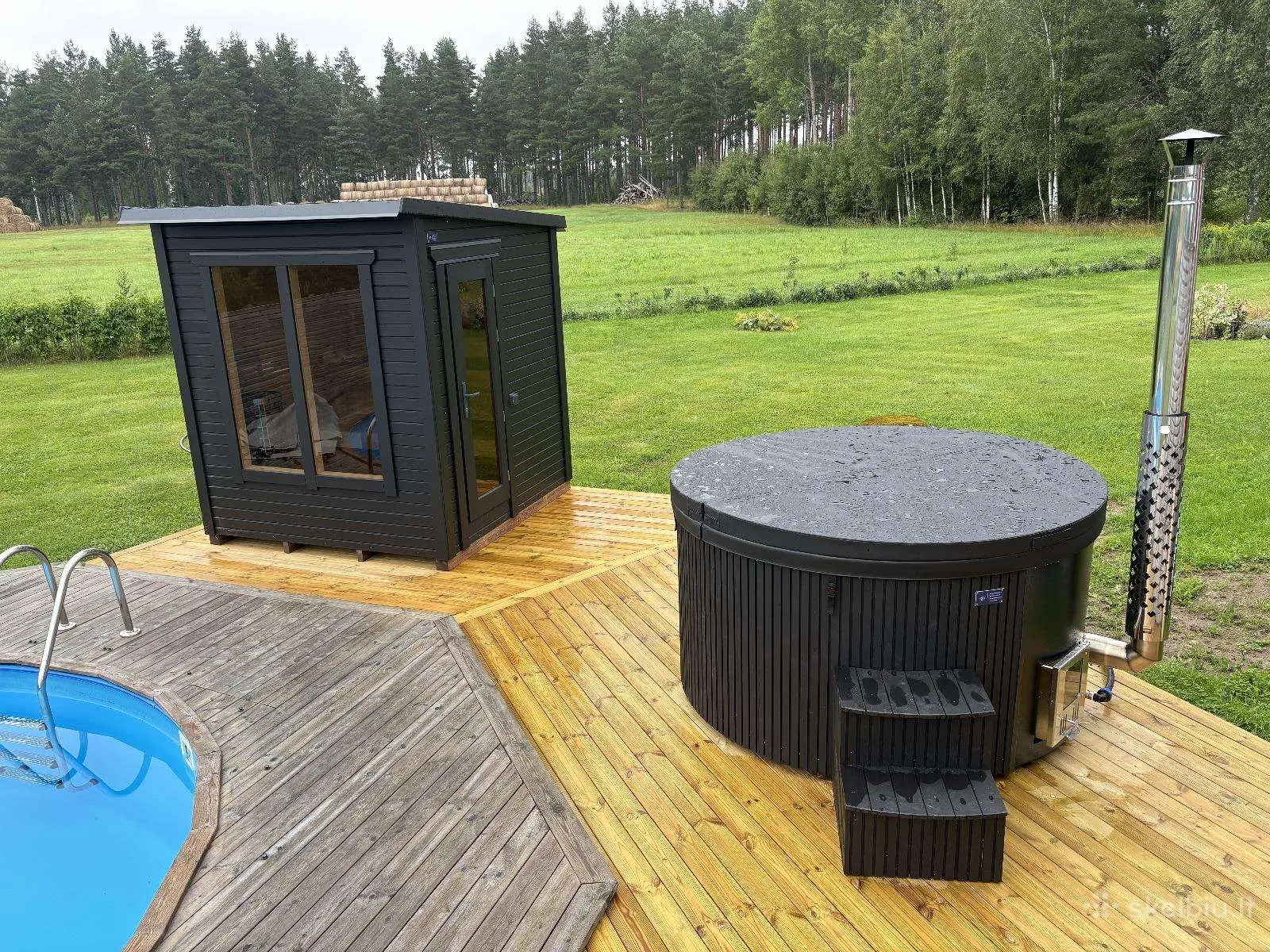 Trædæk med sauna, badetønde og pool i haven