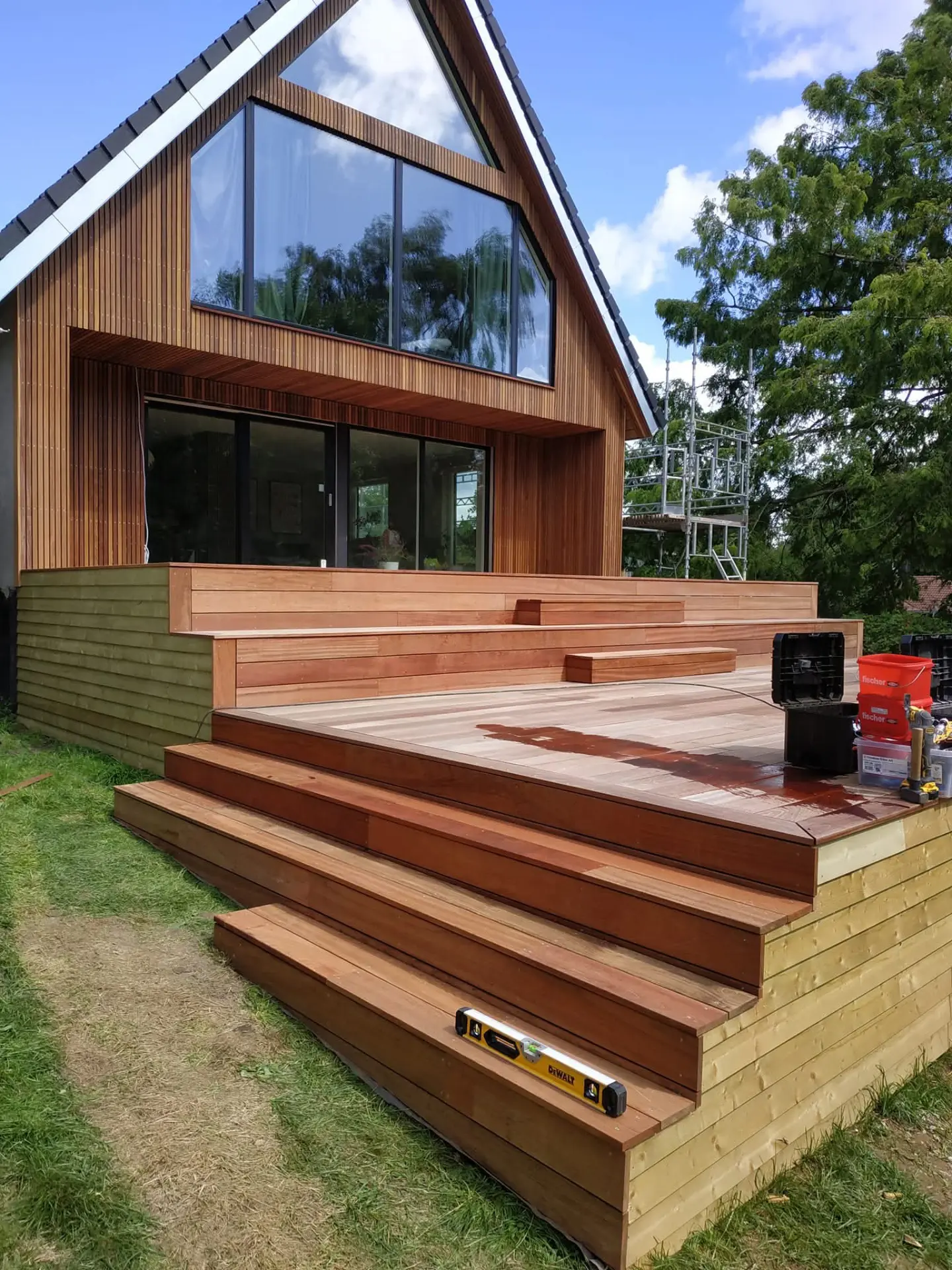 Stort hardwood-trædæk med brede trin og siddekant foran nyt hus